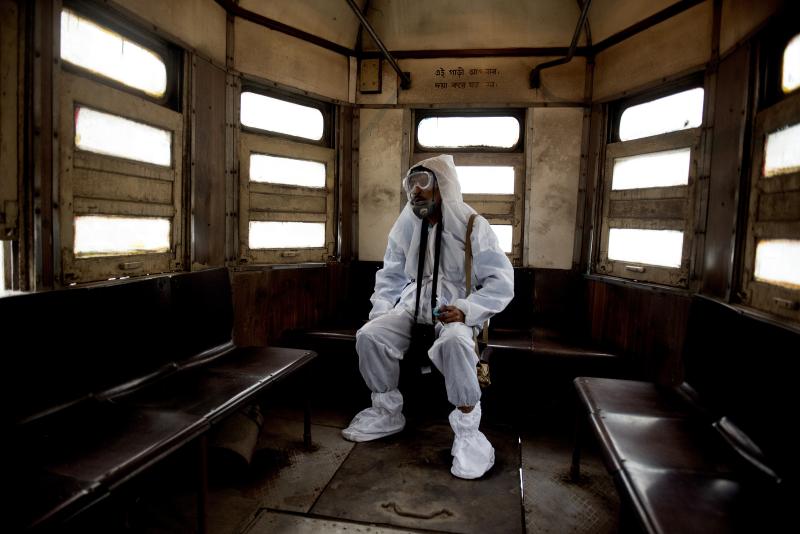 Man rests wearing full-body PPE gear