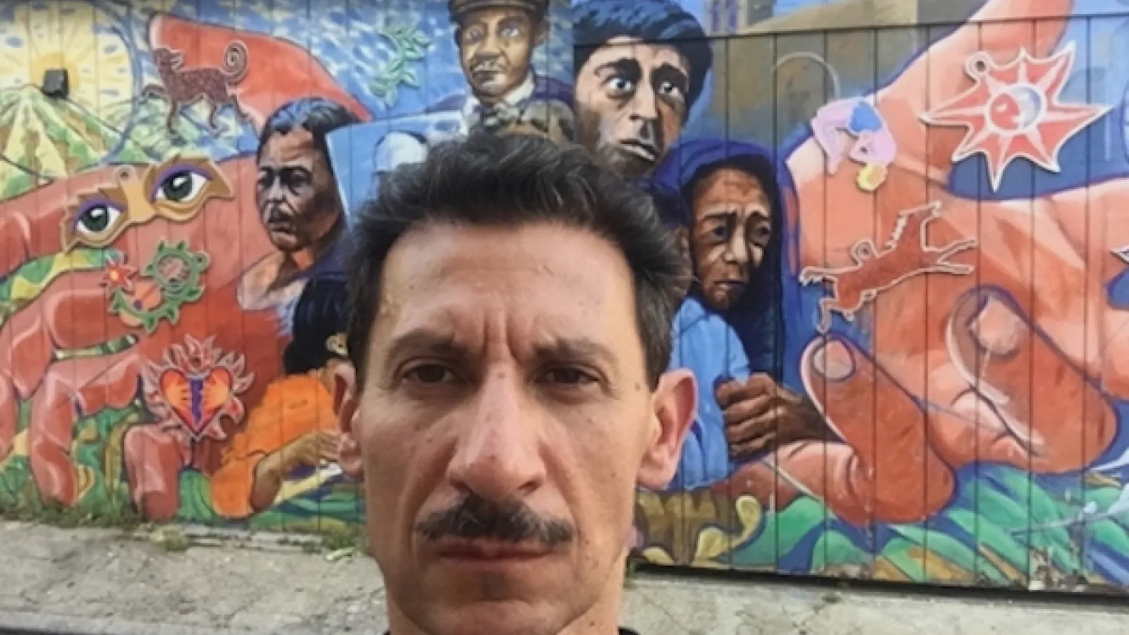 José Medina face in front of mural