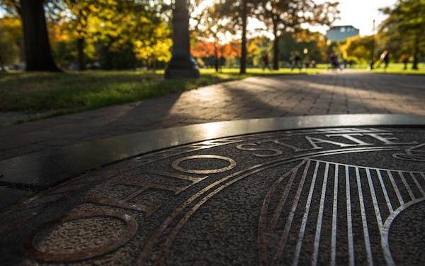 OSU seal on the sidewalk in the rays of morning light