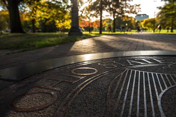 OSU seal on the sidewalk in the rays of morning light